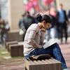 Student sitting on bench on campus 